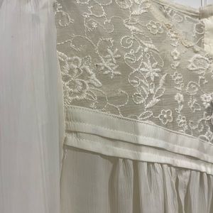 Flowy cream dress top with ruched sleeves and buttoned upper back.